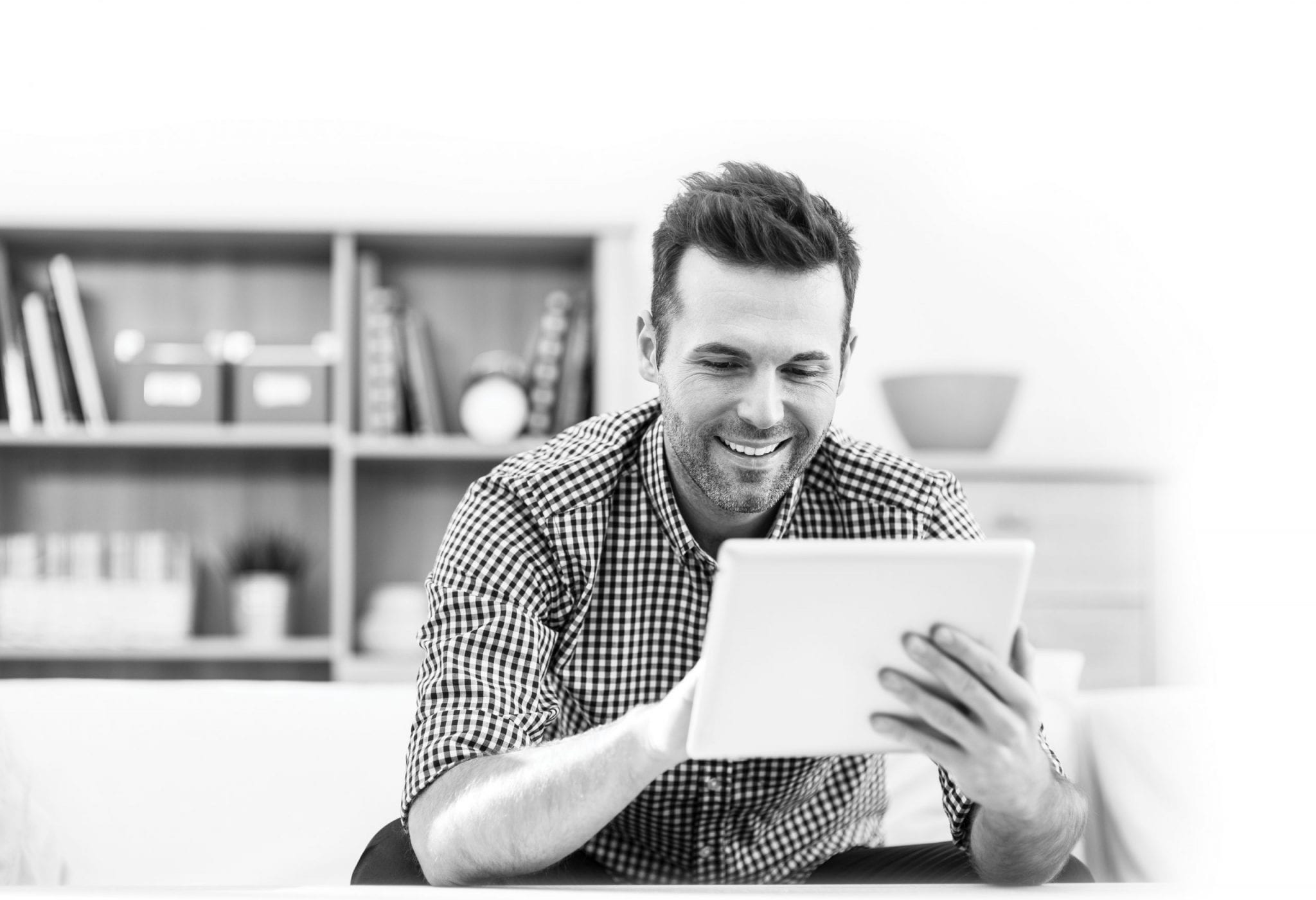 Smiling handsome man using digital tablet at home