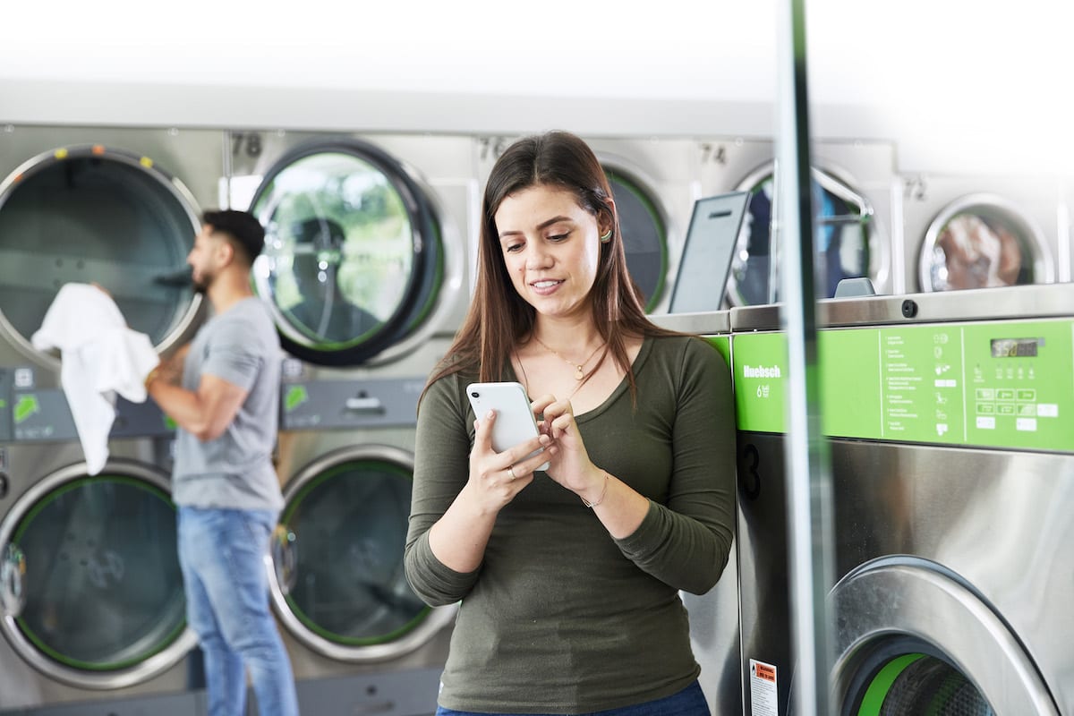 woman on her phone at a Huebsch laundromat