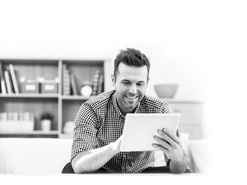 Smiling handsome man using digital tablet at home