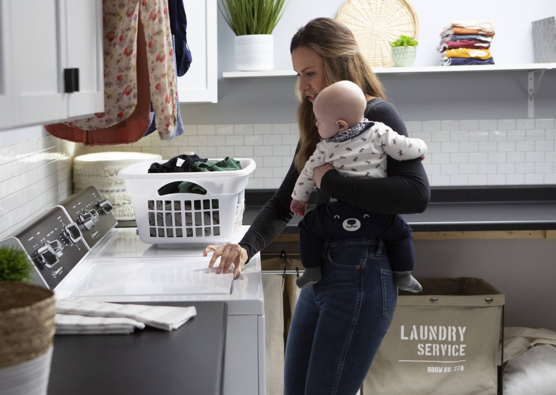 LowestCosts-HighestSatisfaction mother holding baby and doing laundry
