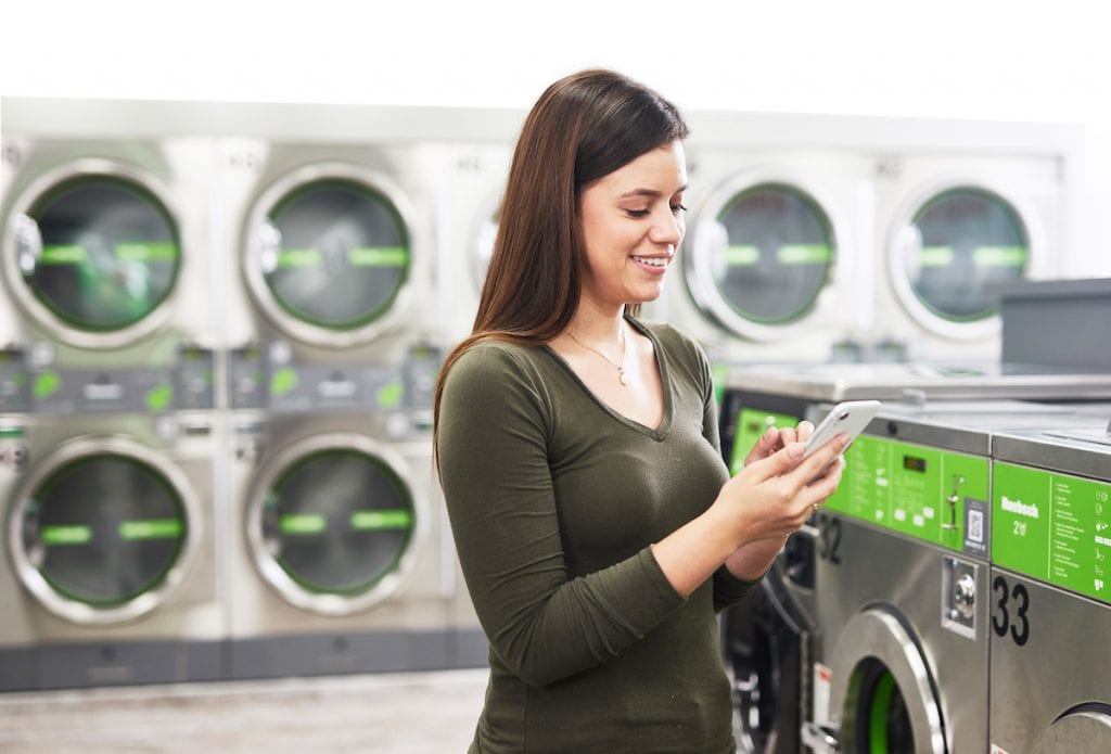 woman on her phone in Huebsch laundromat