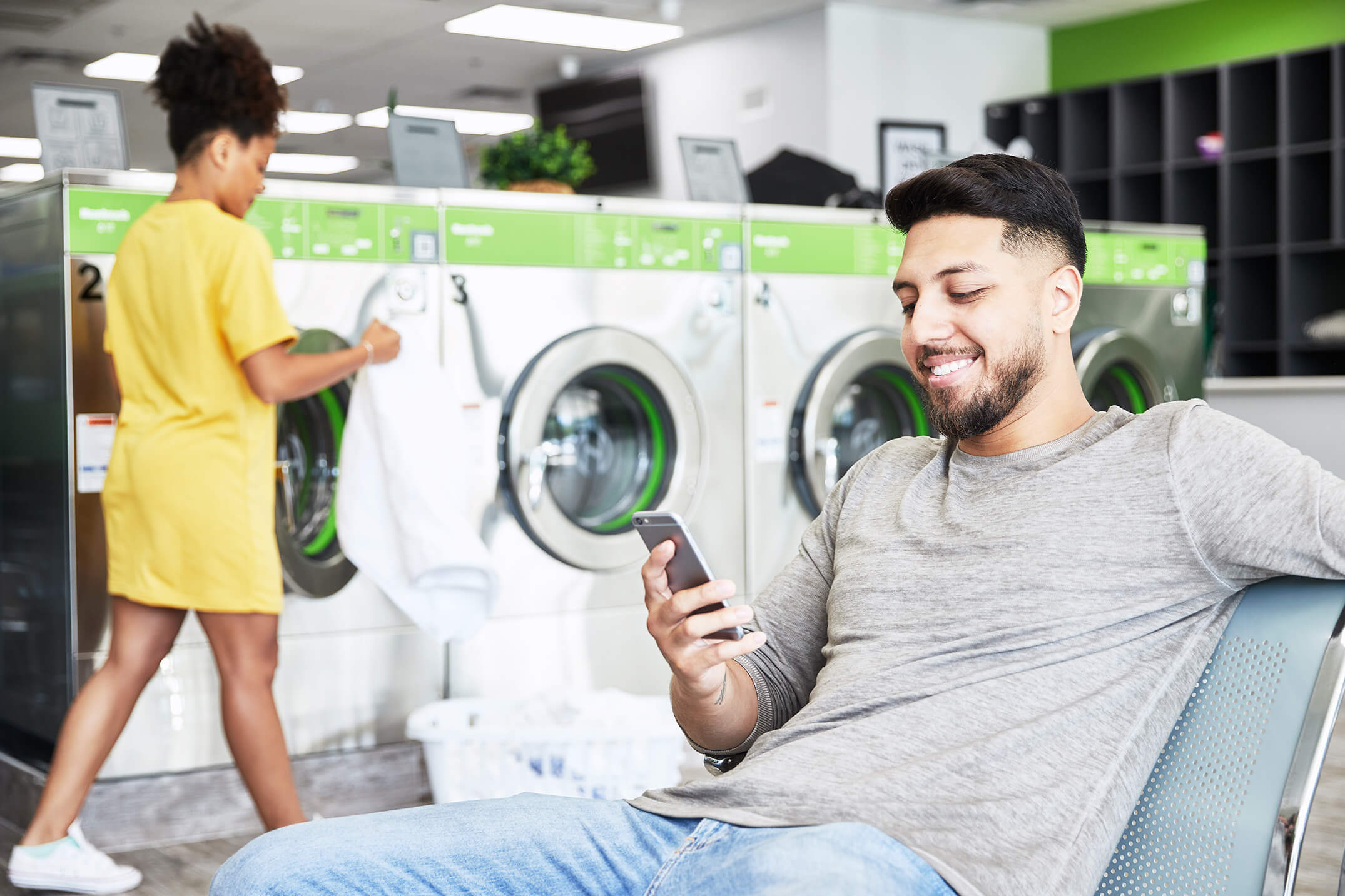 Two people doing laundry at a laundromat