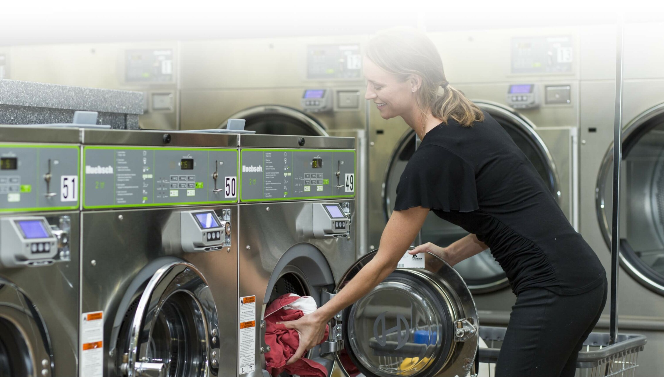 woman putting laundry into machine