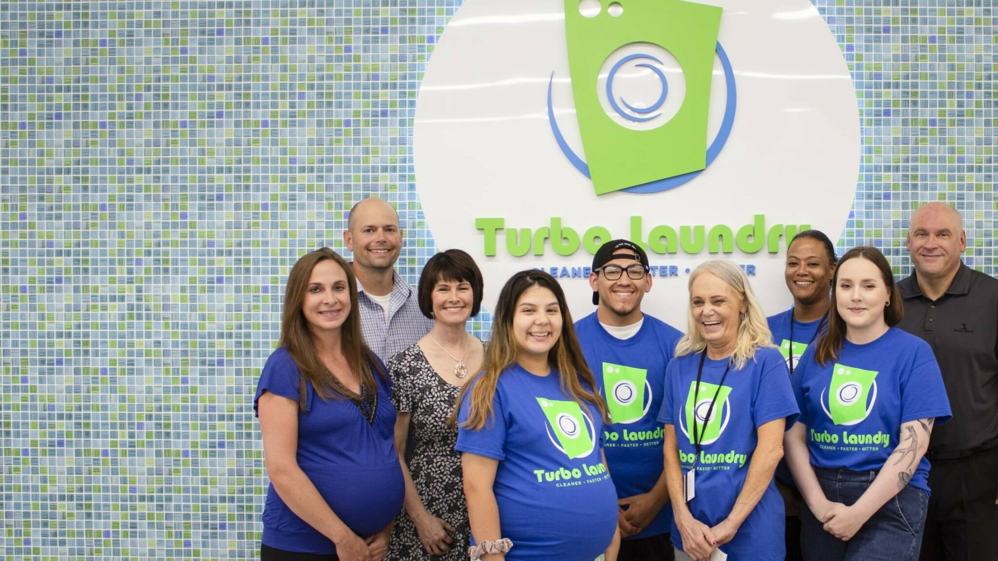 entire Turbo Laundry team in front of logo
