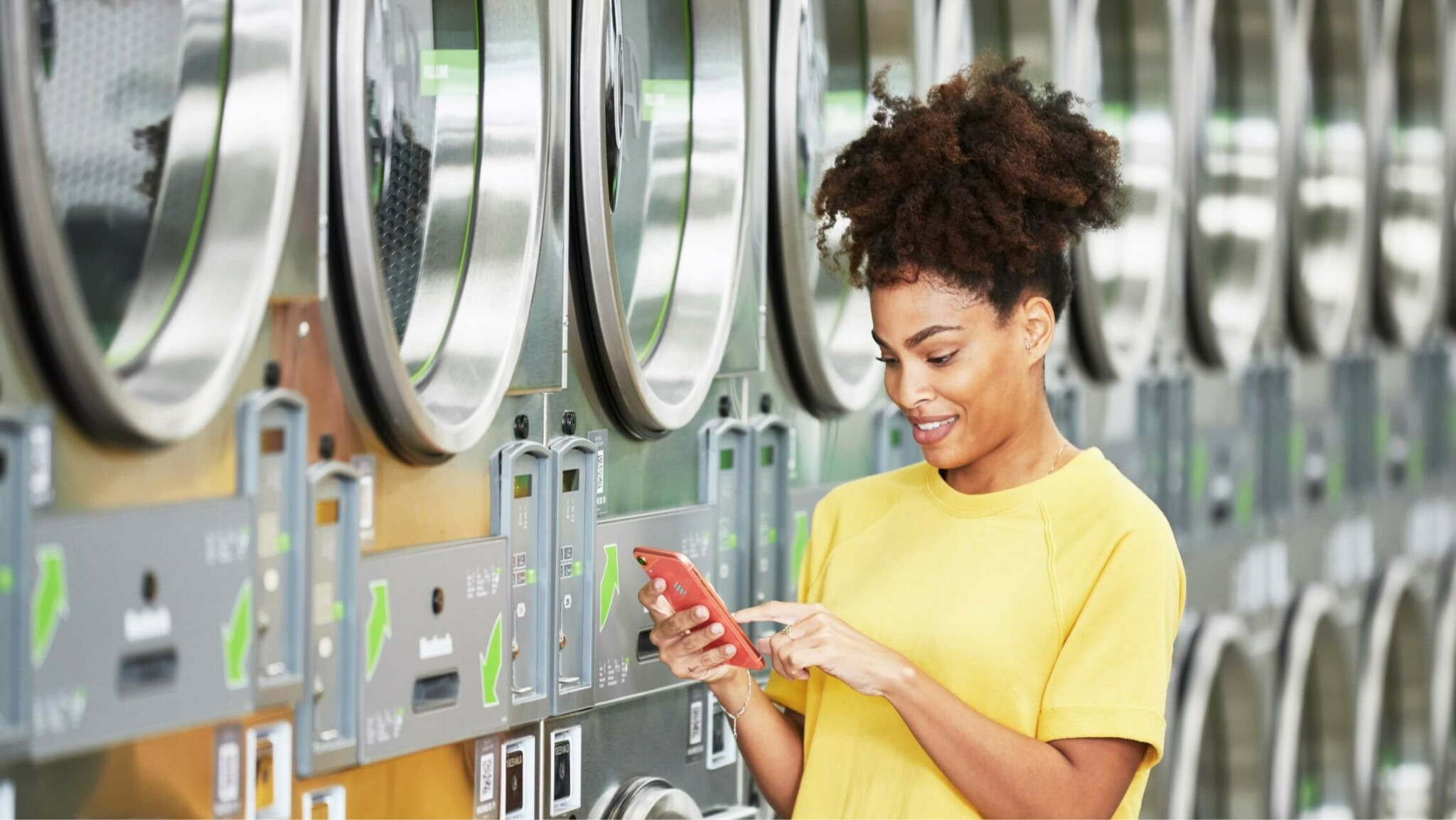woman standing next to row of washing machines