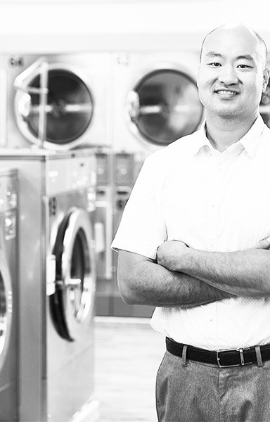 man smiling in front of laundromat